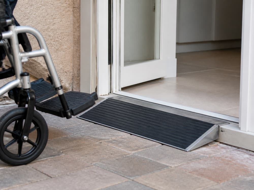 Low-profile threshold ramp bridging a small doorway transition for a wheelchair